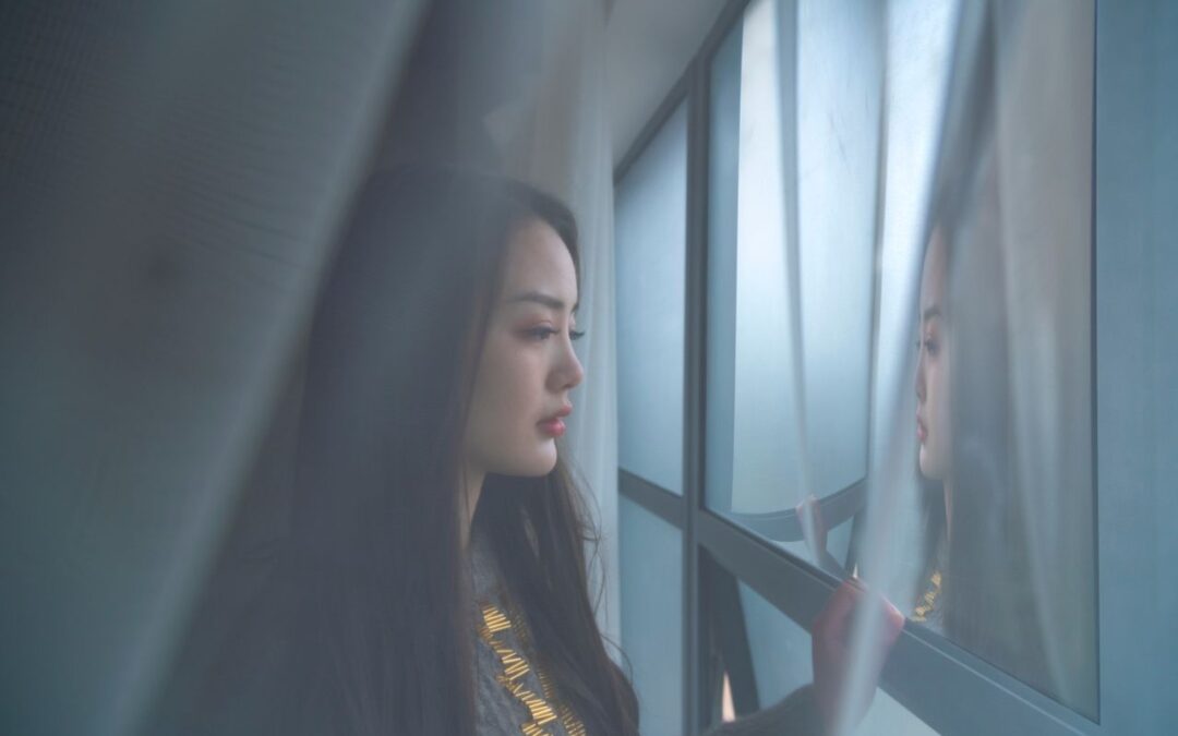 gauzy photo of a woman looking out the window, looking moody